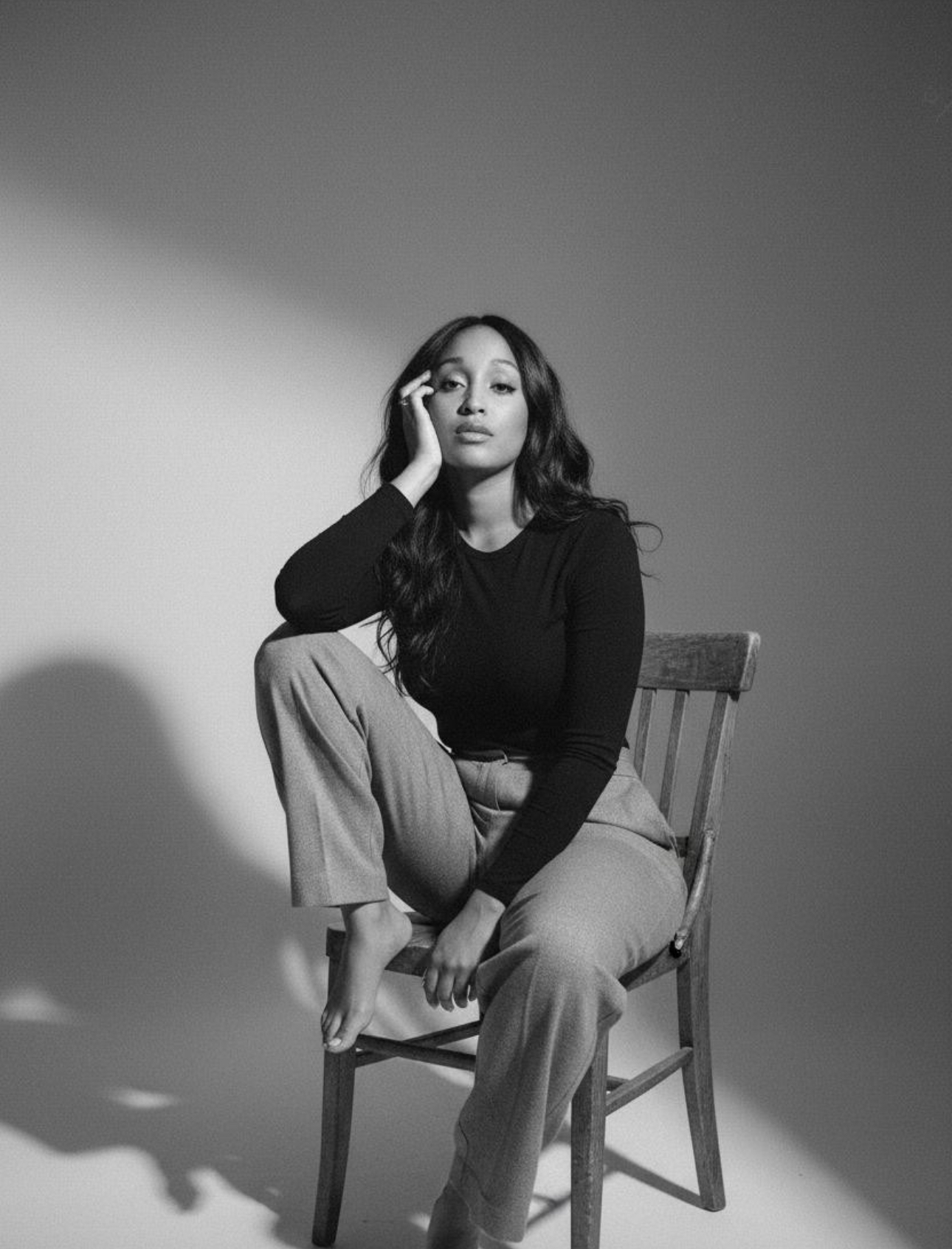 Savannah Arielle, founder of SELÍN, seated on a wooden chair in soft studio light.